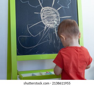 young boy drawing on chalkboard on isolated background