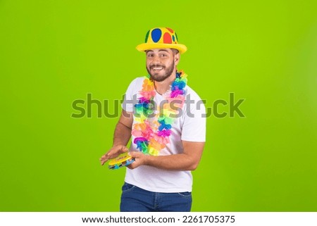 Young boy dressed for carnival with a tambourine in his hands. Young man dressed in carnival costume playing tambourine at carnival party