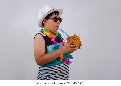 A Young Boy Dressed In His Blue Striped Tank Top, A Colorful Flower Necklace, A White Hat, Sunglasses And Walks While Sipping On His Pina Colada. Boy Dressed In Beach Clothes On White Background