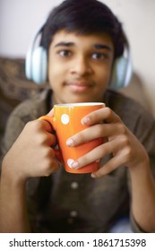 Young Boy Drinking Coffee At Home With Listening To Music	
