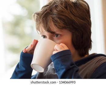 Young Boy Drinking A Hot Chocolate