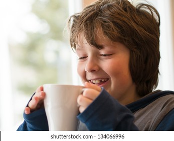 Young Boy Drinking A Hot Chocolate