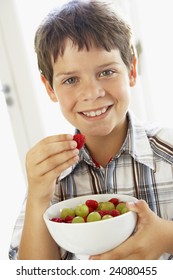 Young Boy Eating Bowl Of Fresh Fruit