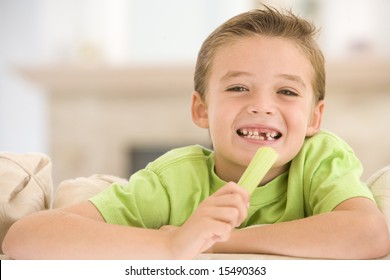 Young Boy Eating Celery In Living Room Smiling