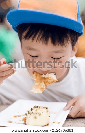 A young boy eats xiao long bao 