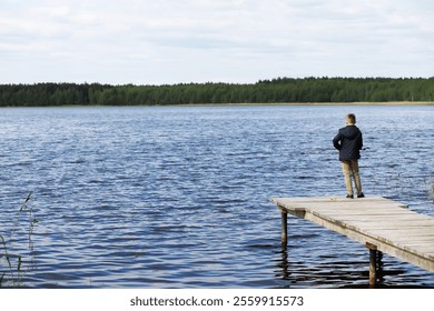 Young Boy Enjoying a Peaceful Summer Day Fishing on a Lakeside Wooden Pier - Powered by Shutterstock