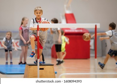 Young boy exercises with a basketball ball in a sports hall