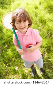 Young Boy In Field With Net And Bug Catcher