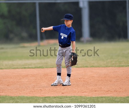 Young boy fielding and throwing the ball in a baseball game