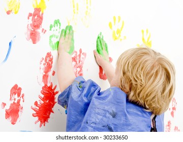 Young Boy Finger Painting On A Wall