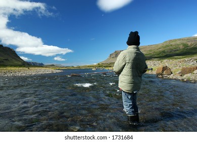 A Young Boy Fishing In A Great North Atlantic Salmon River Waiting For The Fish To Bite