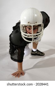 Young Boy In Football Uniform In Three Point Stance.