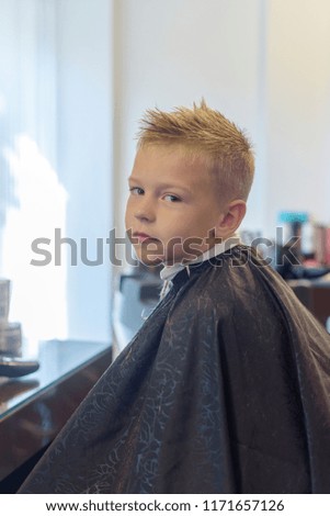 Similar – Beautiful boy getting a haircut with scissors