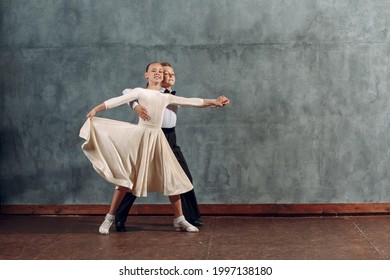 Young boy and girl dancers dances at ballroom dance Viennese Waltz.
