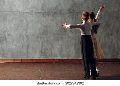 Young Boy And Girl Dancing In Ballroom Dance Viennese Waltz.