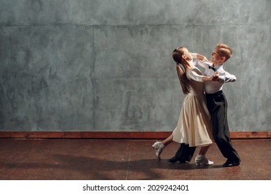 Young boy and girl dancing in ballroom dance Viennese Waltz.