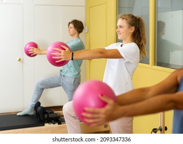 Young boy and girl doing pilates exercises and using small fitness balls.