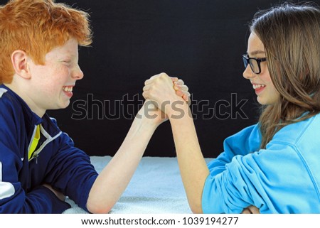 Young Boy And Girl Having An Arm Wrestle Brother And Sister In A Rival Battle Young Boy And Girl Having An Arm Wrestle Brother And Sister In A Rival Battle