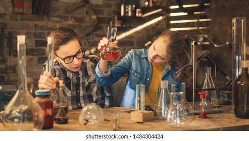 Young Boy And Girl Are Making Chemistry Experiments In A Garage At Home.