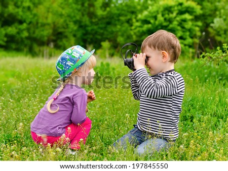 Similar – A boy and a girl in toddlerhood are standing on a log in summer clothes