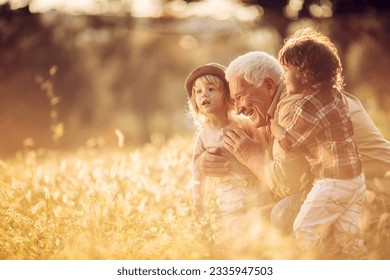 Young boy and girl spending time at the park with their grandfather - Powered by Shutterstock