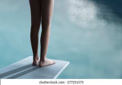 Young boy or girl is standing on a divingboard