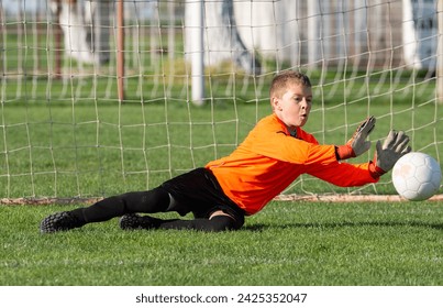 Young Boy Goalkeeper Saving A Football In A Game Of Soccer. - Powered by Shutterstock