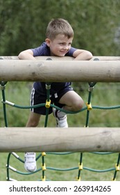 Young Boy Having Fun Climbing An Assault Course
