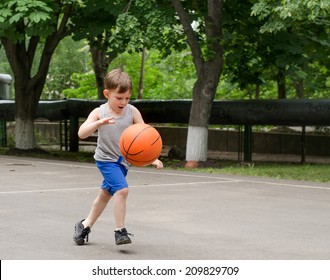 Young Boy Having Fun Playing Basketball Outdoors