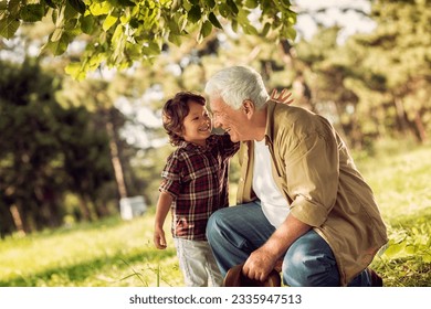 Young boy and his grandfather spending time at the park forest - Powered by Shutterstock