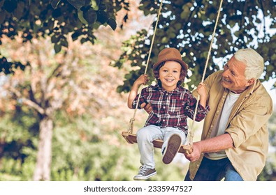 Young boy and his grandfather spending time in the park on a swing - Powered by Shutterstock