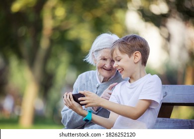 Young boy and his great grandmother using smartphone to makie video call or take selfie. Streaming online video call. Mobile internet. Watching video on smartphone. - Powered by Shutterstock