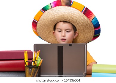 Young Boy In His Mexican Hat Studying On His Laptop Betwwen The Books