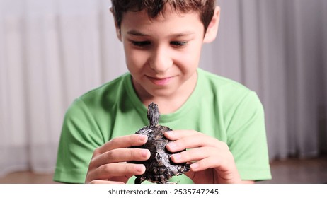 young boy holds a turtle gently, focused on the small reptile in his hands. This image reflects a moment of curiosity and care, representing the bond between children and pets. - Powered by Shutterstock