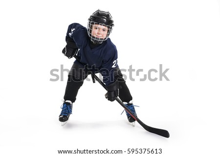 A Young boy in ice hockey gear against white