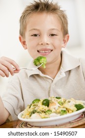 Young Boy Indoors Eating Pasta With Brocoli Smiling