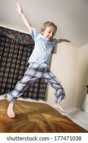 Young Boy Jumping On Bed