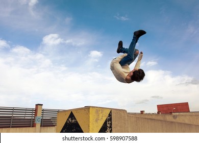 Young Boy Jumping Somersault On The Street.