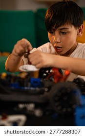 Young boy learning engineering and mechanics, carefully assembling parts of a remote control vehicle, focused on his hobby