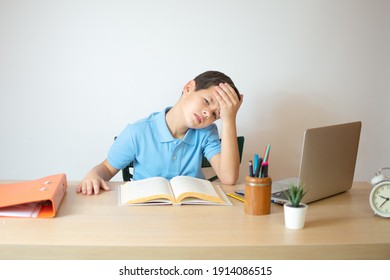 A young boy learning over his homework reading his workbook. - Powered by Shutterstock