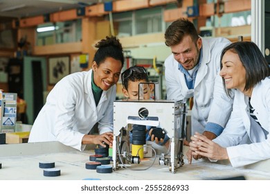 A young boy learns to operate a robotic arm, guided by smiling scientists in laboratory coats in a well-equipped classroom. - Powered by Shutterstock