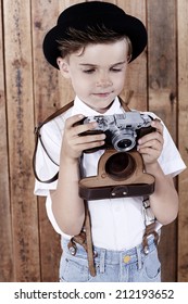Young boy looking at old camera 