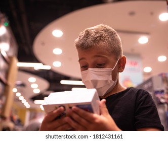 A Young Boy Looks At Toys On Display At A Toy Store In A Shopping Mall