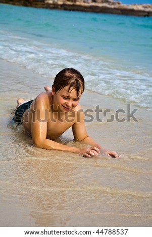 One happy little boy playing on the beach