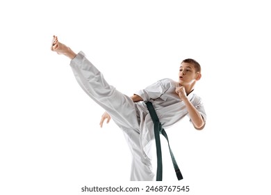 Young boy, martial artist in white kimono performs karate high kick, demonstrating skill and agility isolated on white studio background. Concept of sport, martial arts, combat sport, health - Powered by Shutterstock