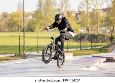 A young boy mastered riding a low trick bike,bmx, I try to lift the front wheel, he is fascinated, smiles, keeps his feet on the pedals lifting himself up - Powered by Shutterstock