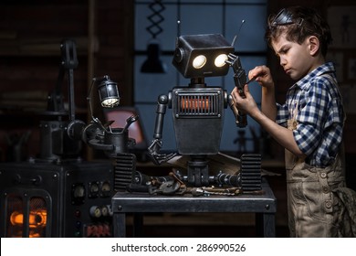 Young boy mechanic repairing the robot in the workshop at night - Powered by Shutterstock