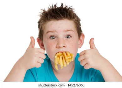 Young boy with a mouth full of chips fries. Isolated on white background.