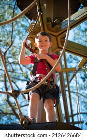 Young Boy Navigating Treetop Ropes Course