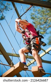 Young Boy Navigating Treetop Ropes Course